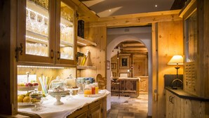 A wooden interior with a breakfast buffet, a dining area, and a kitchen. - Bio Boutique Hotel Laurino (Cavalese)