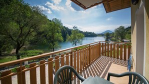 A balcony with a view of a river and forest.
