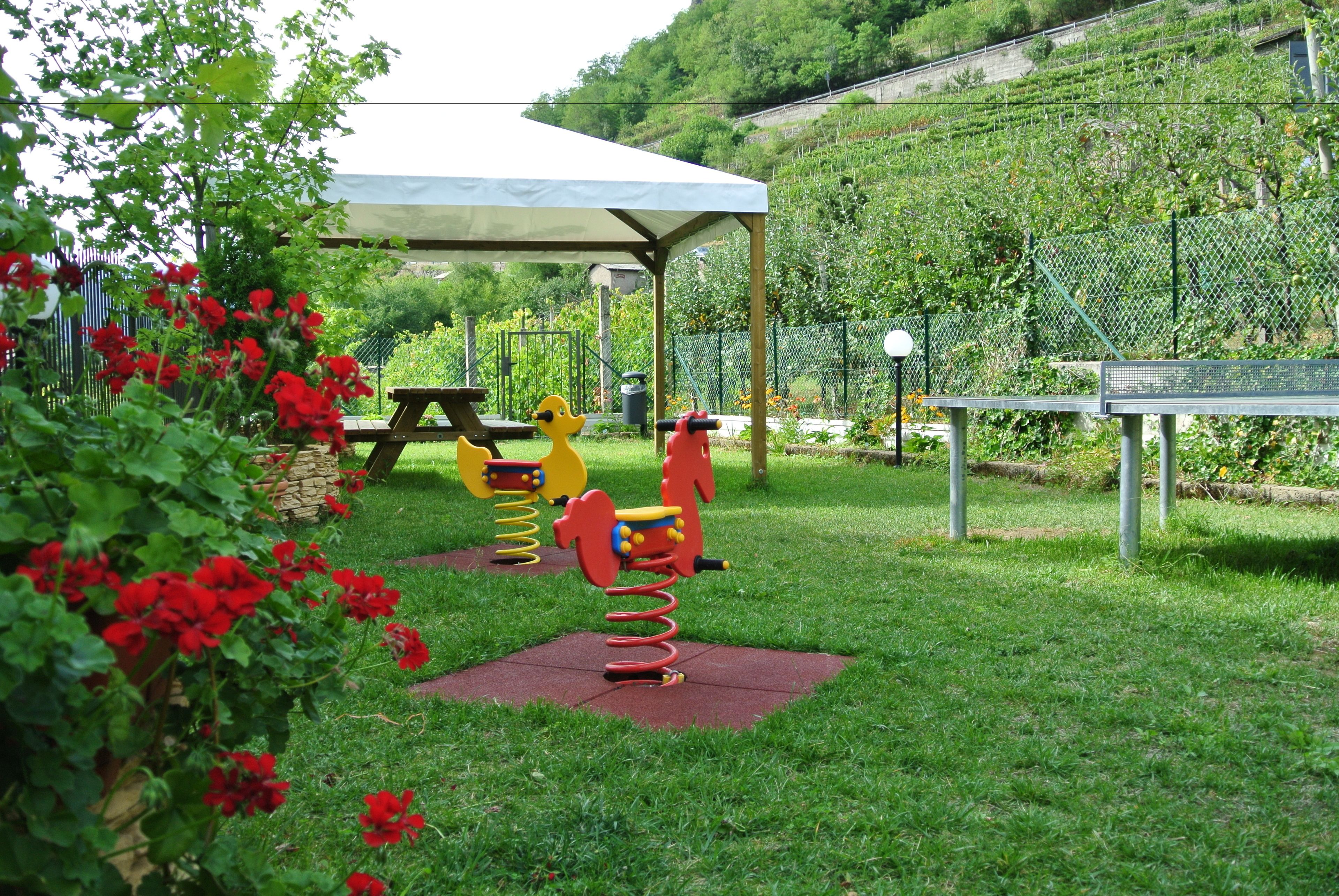 Ein Spielplatz mit Schaukeln und einem überdachten Picknicktisch.