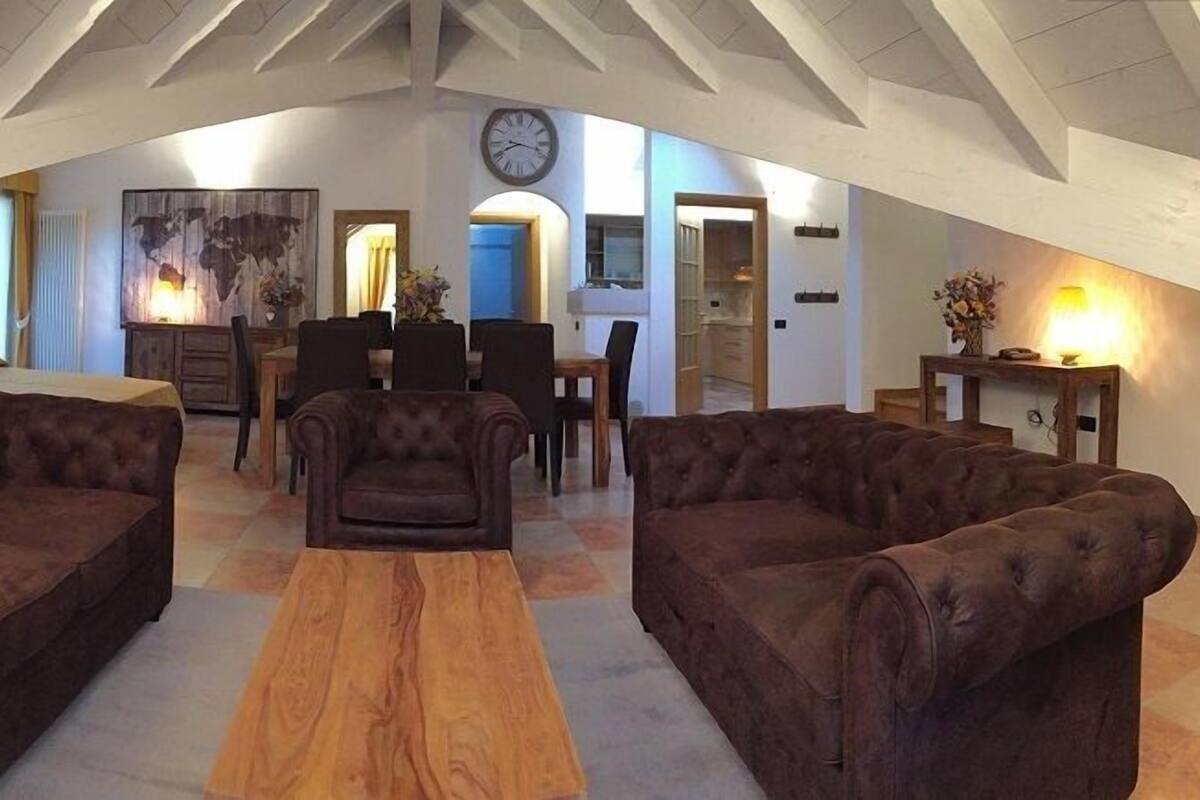 A spacious loft with high ceilings, a dining area, and a cozy seating arrangement.