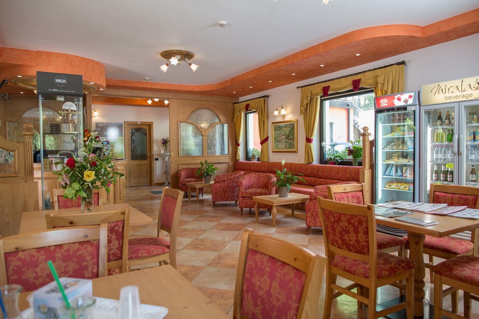 Un accogliente ristorante con arredi in legno, un frigorifero per bevande e una zona con vista sulla strada.