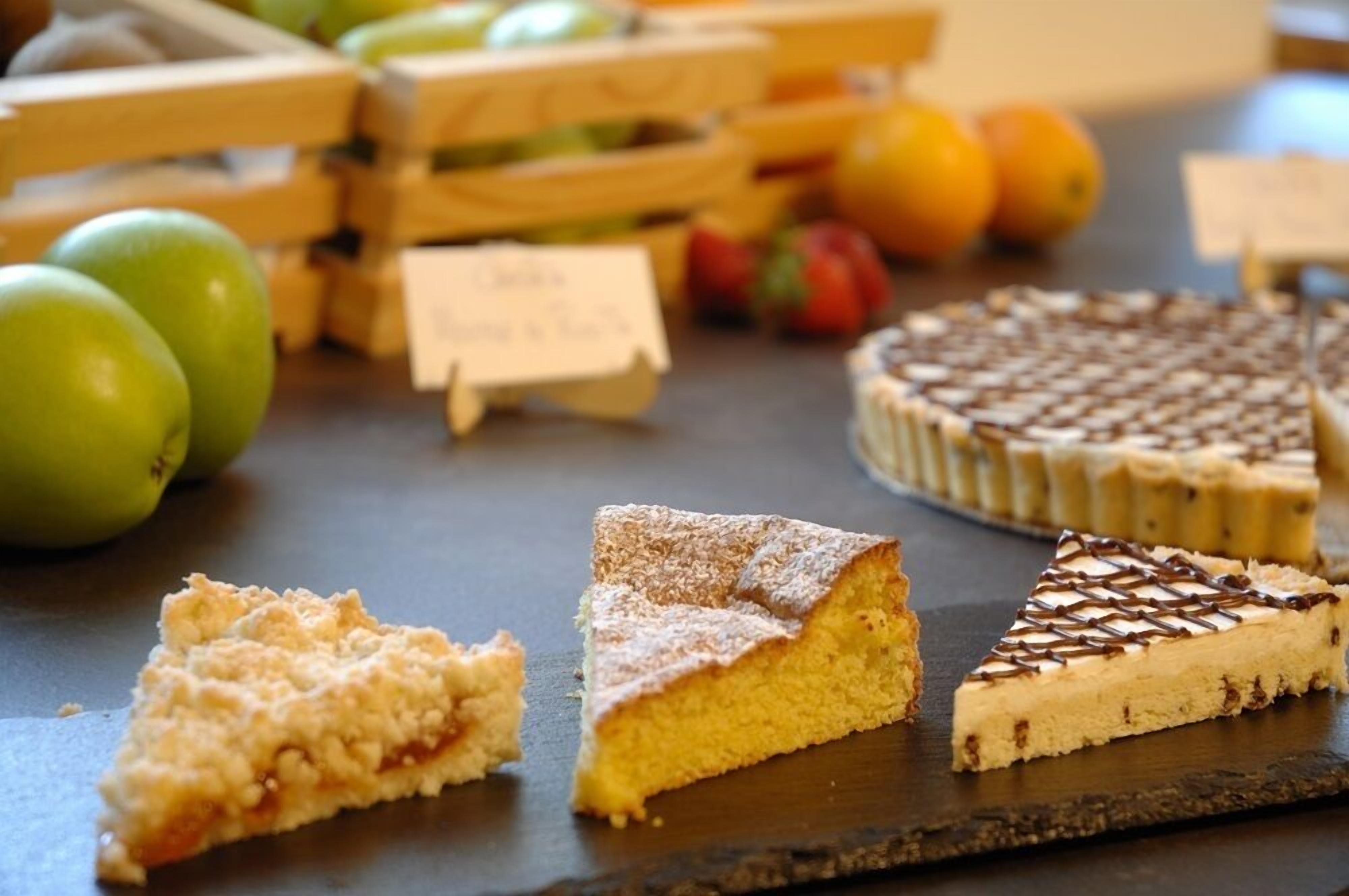 Une sélection de desserts est présentée sur une table en bois, et une pancarte indique un prix de 5,00 $.
