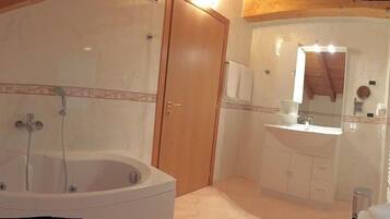 Une salle de bain avec une baignoire, un lavabo et un miroir.