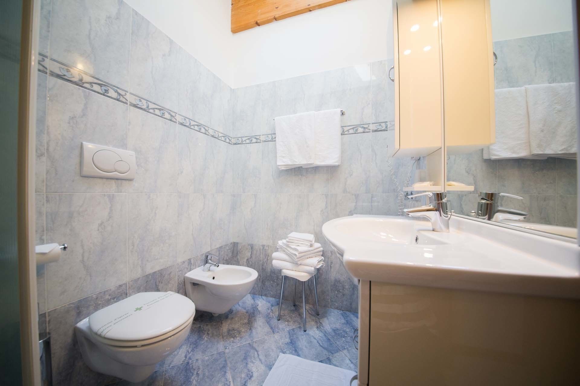 Une salle de bain équipée d’un bidet, de toilettes et d’un lavabo.