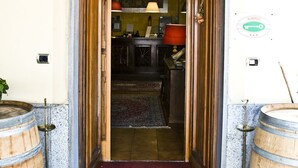 A hotel entrance with a floral archway and a red carpet leading inside. There are wooden barrels on either side of the entrance. - Hotel Bellavista (Bossolasco)