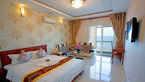 A hotel room with a large bed, a sofa, a table, and a TV. - Romeliess Hotel (Ho Chi Minh City)