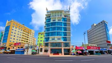 Located on a busy street corner, Romelies Hotel features a striking glass facade and curved design.