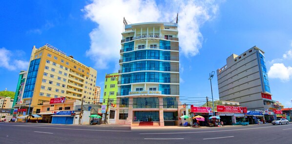 Hotel com design moderno, vários andares e uma placa bem visível.