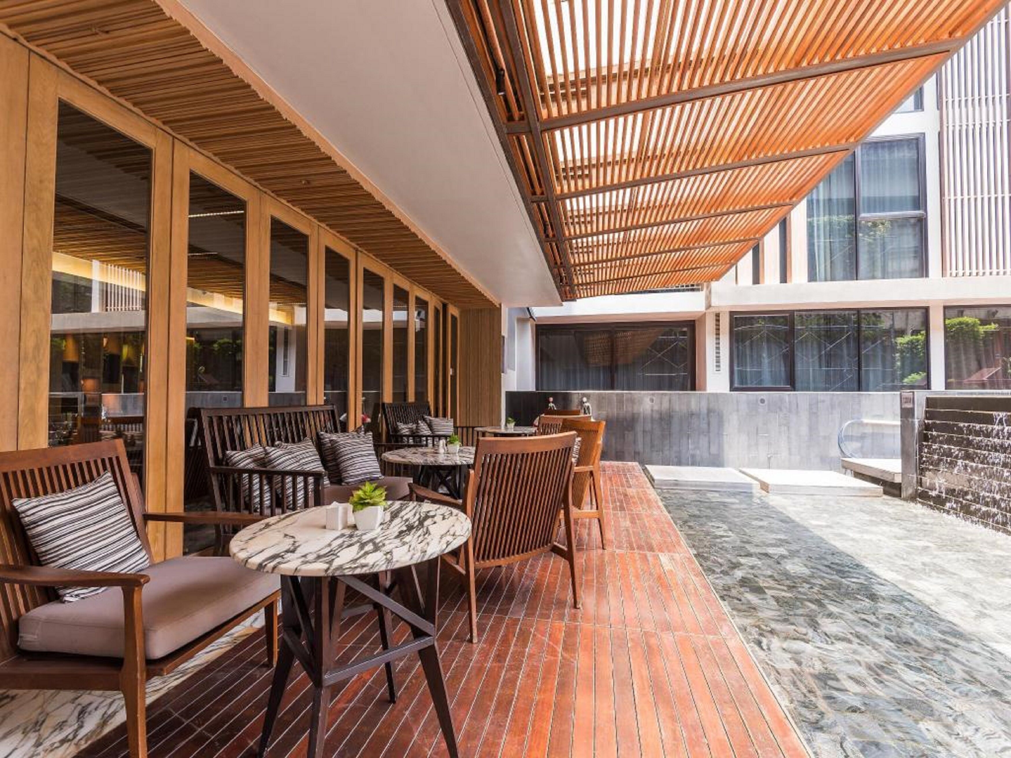 An outdoor seating area with wooden furniture and a pergola.