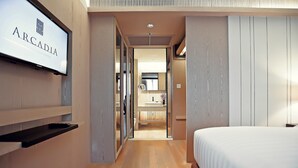 A modern hotel room with a large bed, a TV mounted on the wall, and a wooden floor.