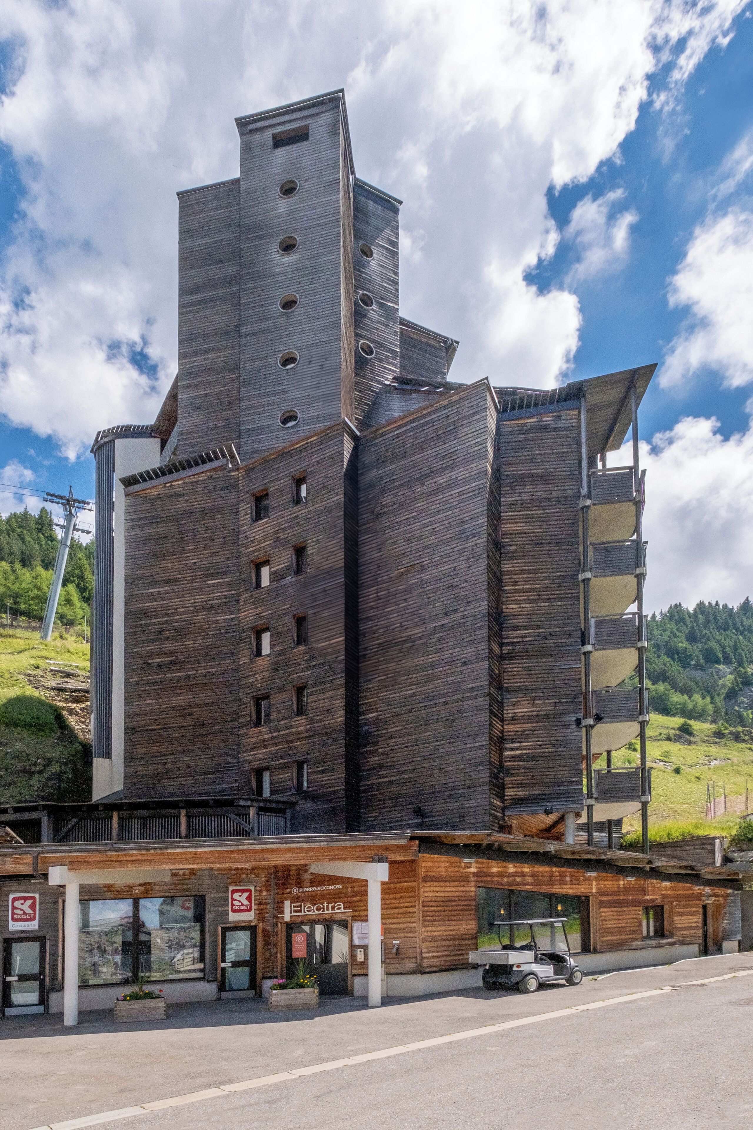 Een modern gebouw met een uniek architectonisch ontwerp, met meerdere verdiepingen en balkons.