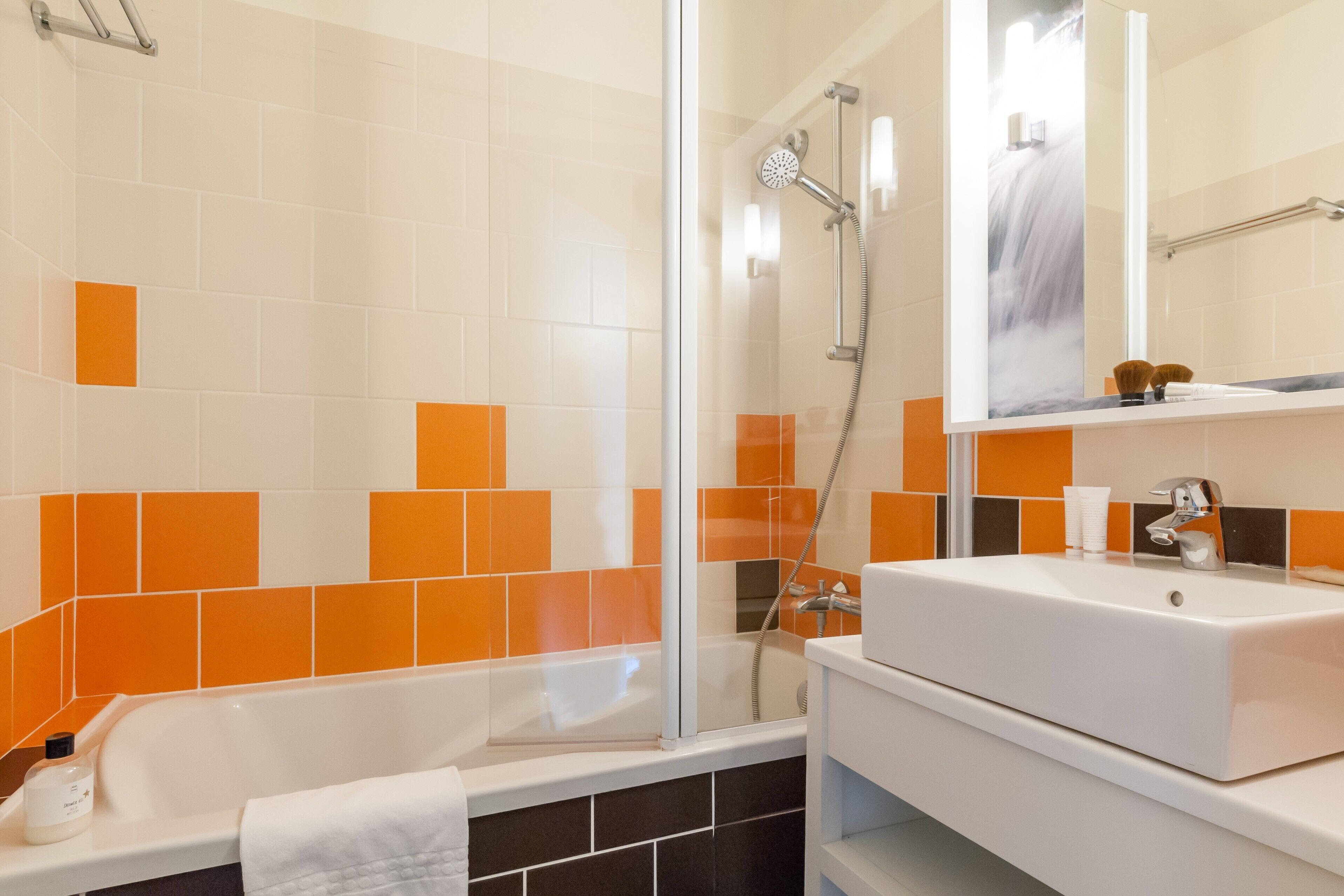 A modern bathroom with a bathtub, a shower, and a sink.