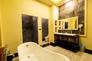 A bathroom with a bathtub, a toilet, and a sink with a mirror. - Mylaohome Hotel & Spa (Luang Prabang)