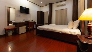 A hotel room with a bed, desk, chair, and a television. - Mylaohome Hotel & Spa (Luang Prabang)