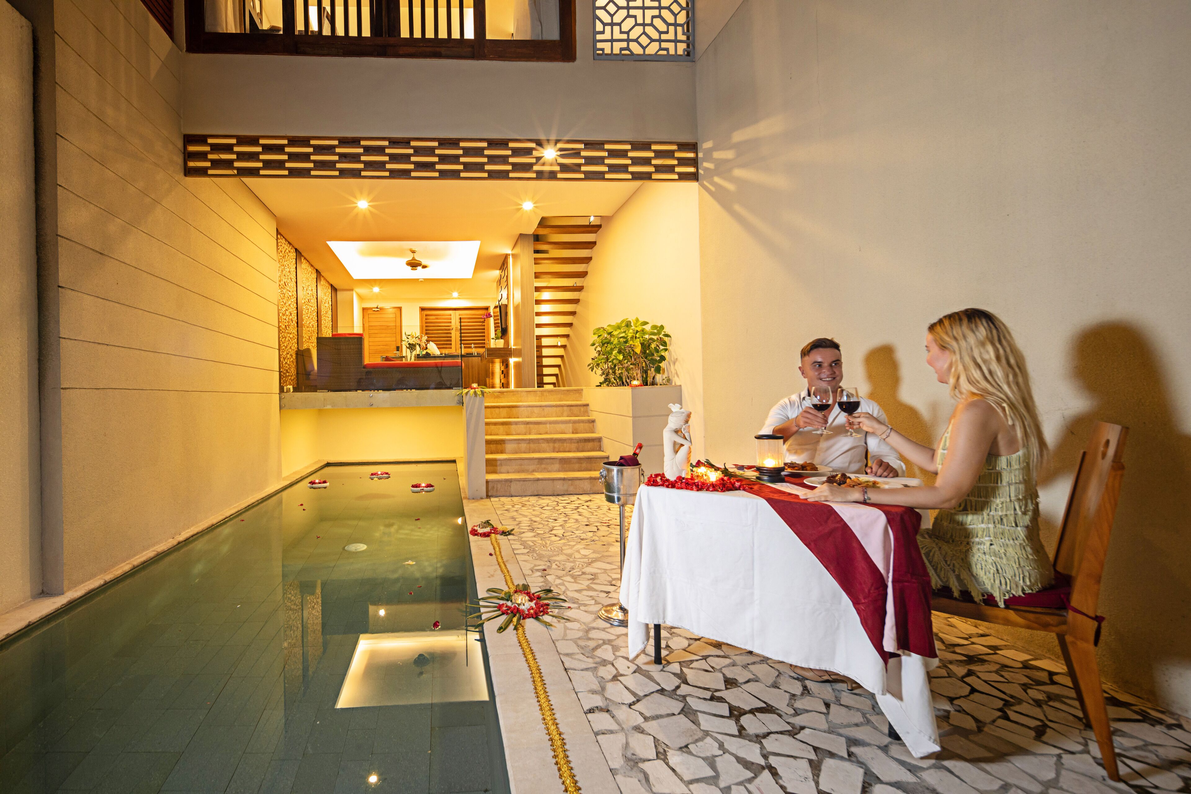 A dining area with a pool, a staircase, and a view of the interior.