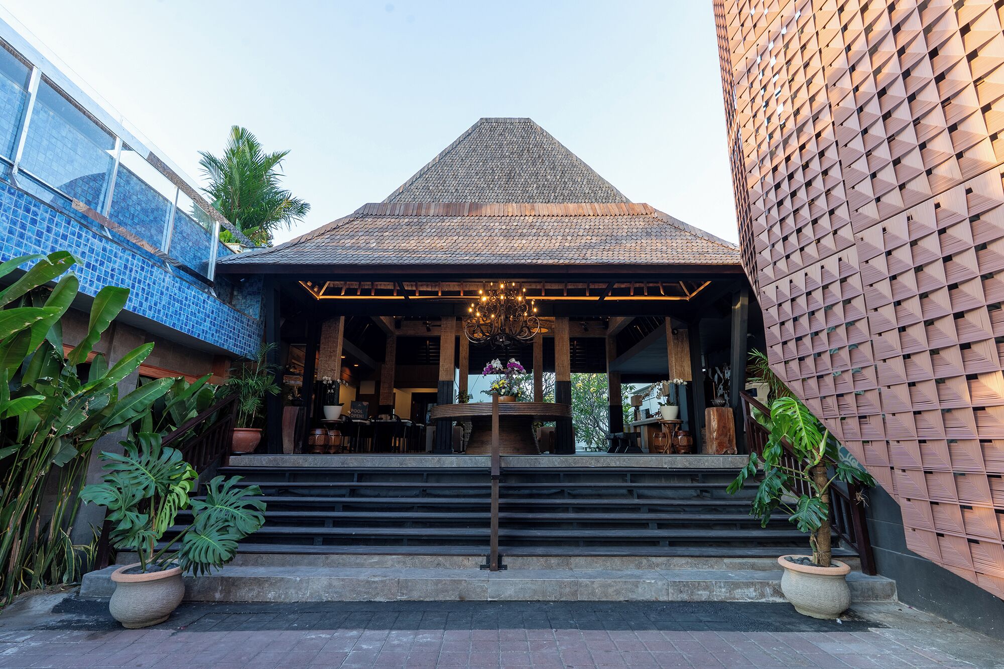 A traditional building with a tiled roof, a covered entrance with steps, and a chandelier.
