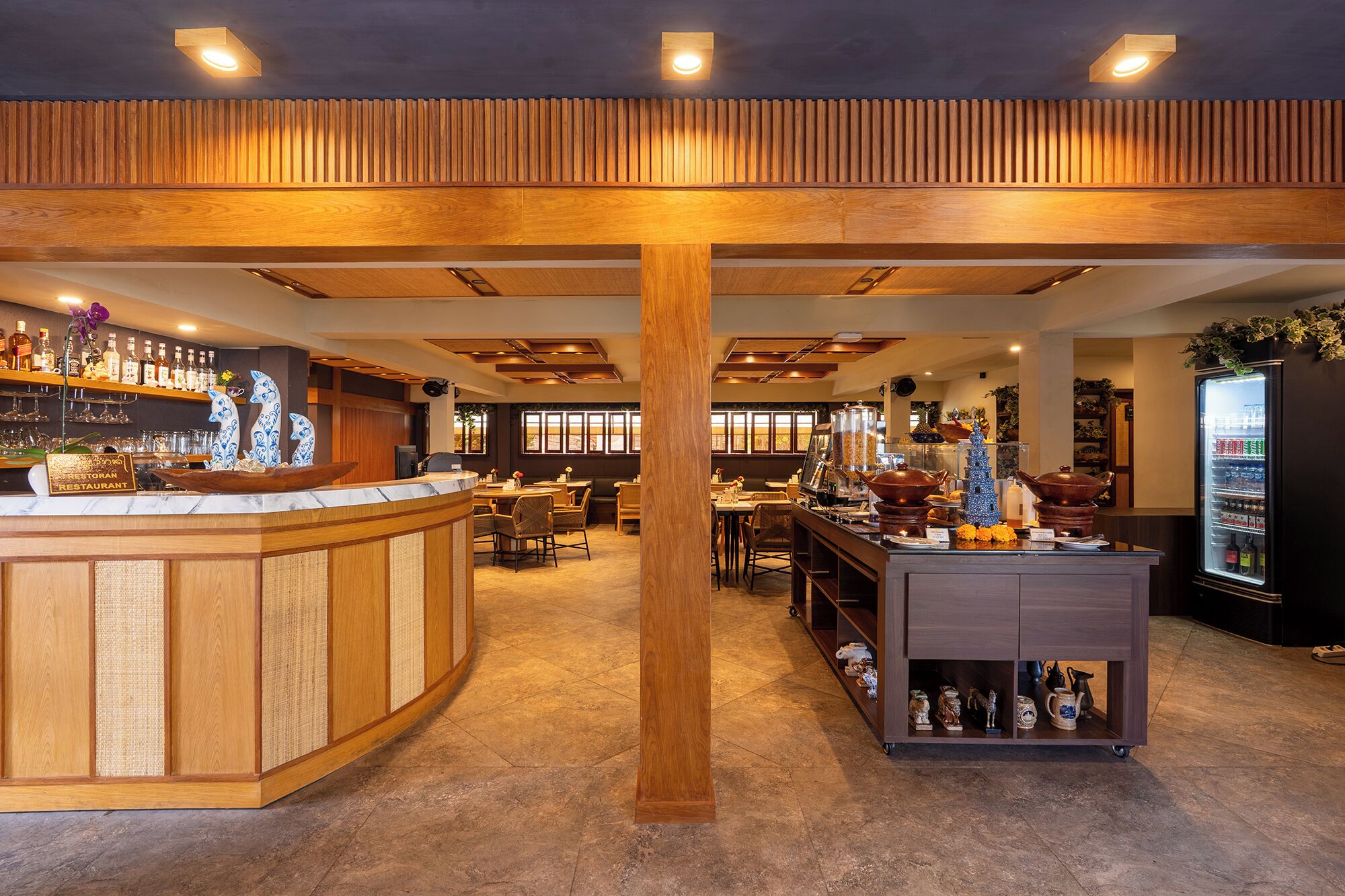 A restaurant interior with a wooden bar, seating area, and a decorative display case.