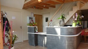A kitchen with a built-in island, a refrigerator, and a staircase leading to another level. - Auberge de la Baie (Pontorson)