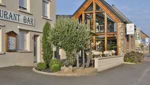 A restaurant bar with outdoor seating and a visible sign for a hotel. - Auberge de la Baie (Pontorson)