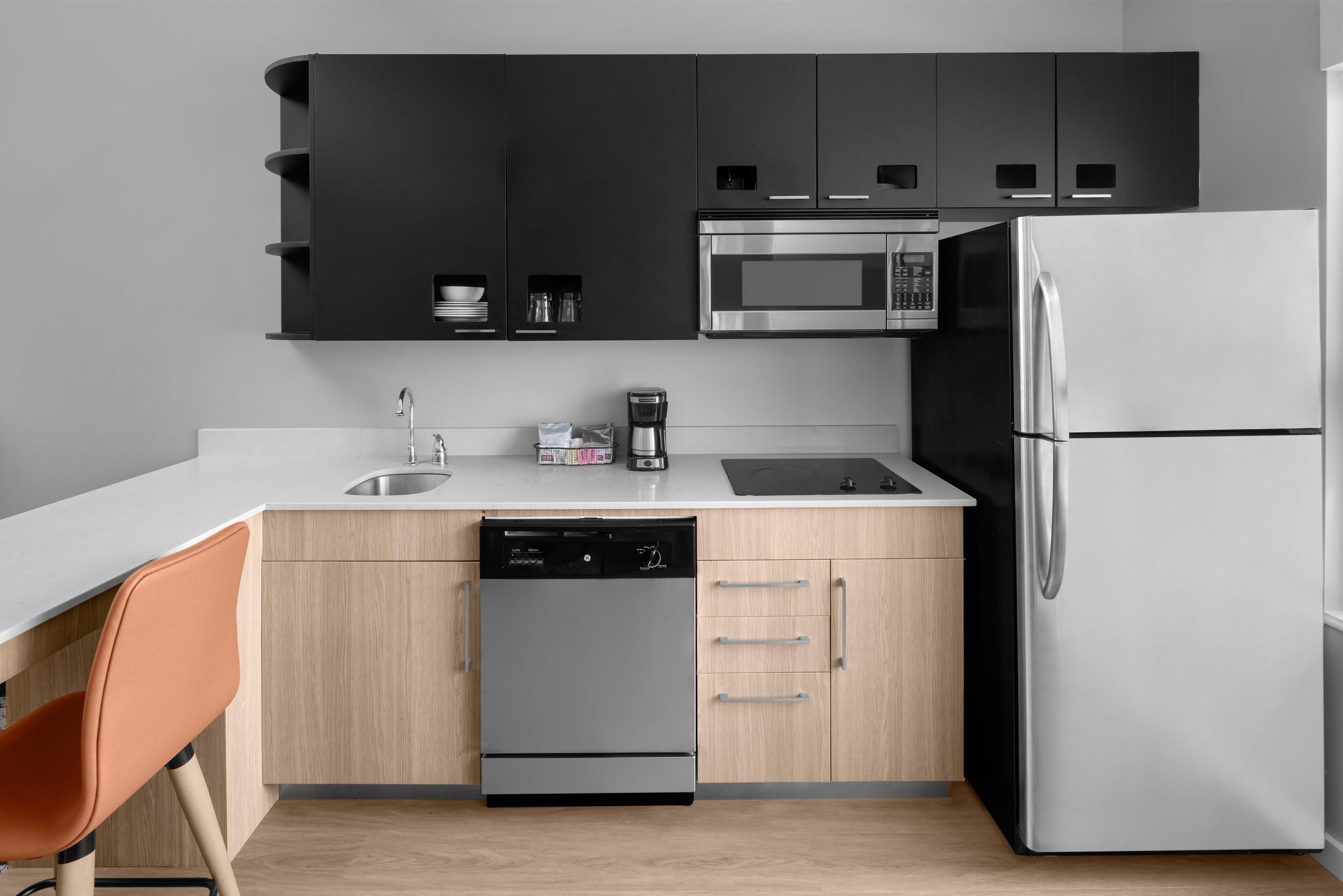 Una cocina moderna con lavavajillas, microondas y refrigerador.