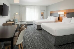 A hotel room with two beds, a desk, chairs, a TV, a lamp, and a window with curtains. - TownePlace Suites Redding (Redding)