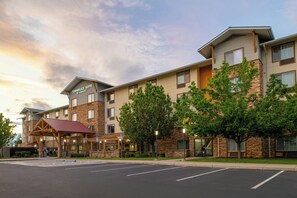 A hotel with a stone facade, multiple windows, and a covered entrance. - TownePlace Suites Redding (Redding)