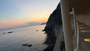 A coastal view with a rocky cliff and calm sea.