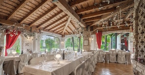 A restaurant with wooden beams, tables set for dining, and natural light from large windows. - Principato di Ariis (Rivignano Teor)