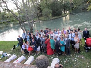 A group of people gathered outdoors near a body of water, possibly for a wedding or event. - Principato di Ariis (Rivignano Teor)