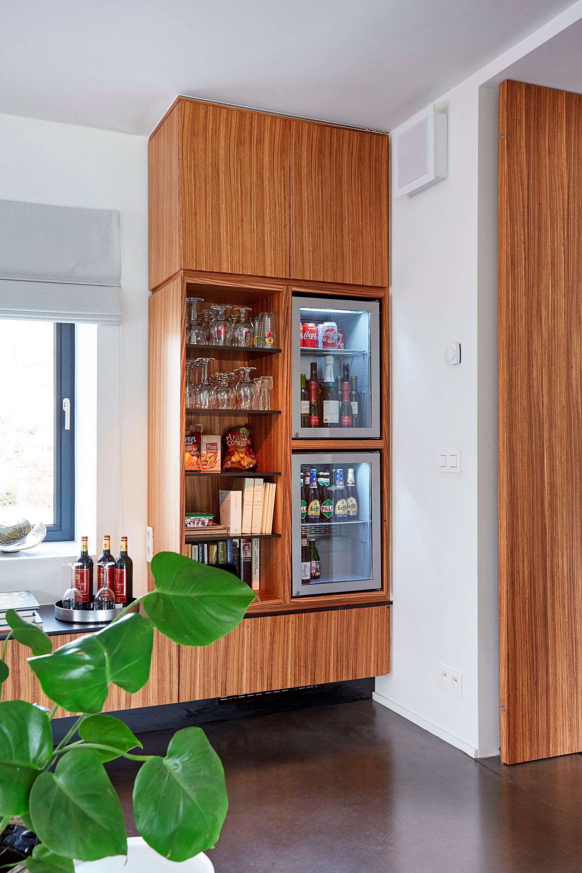Una cocina con muebles de madera, un refrigerador de vinos empotrado y un ventanal con vistas.