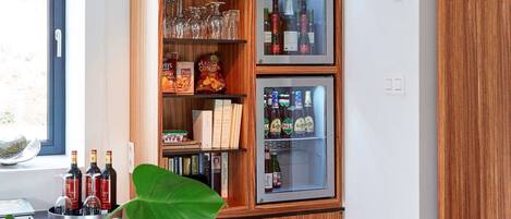 Una cocina con muebles de madera, un refrigerador de vinos empotrado y un ventanal con vistas.