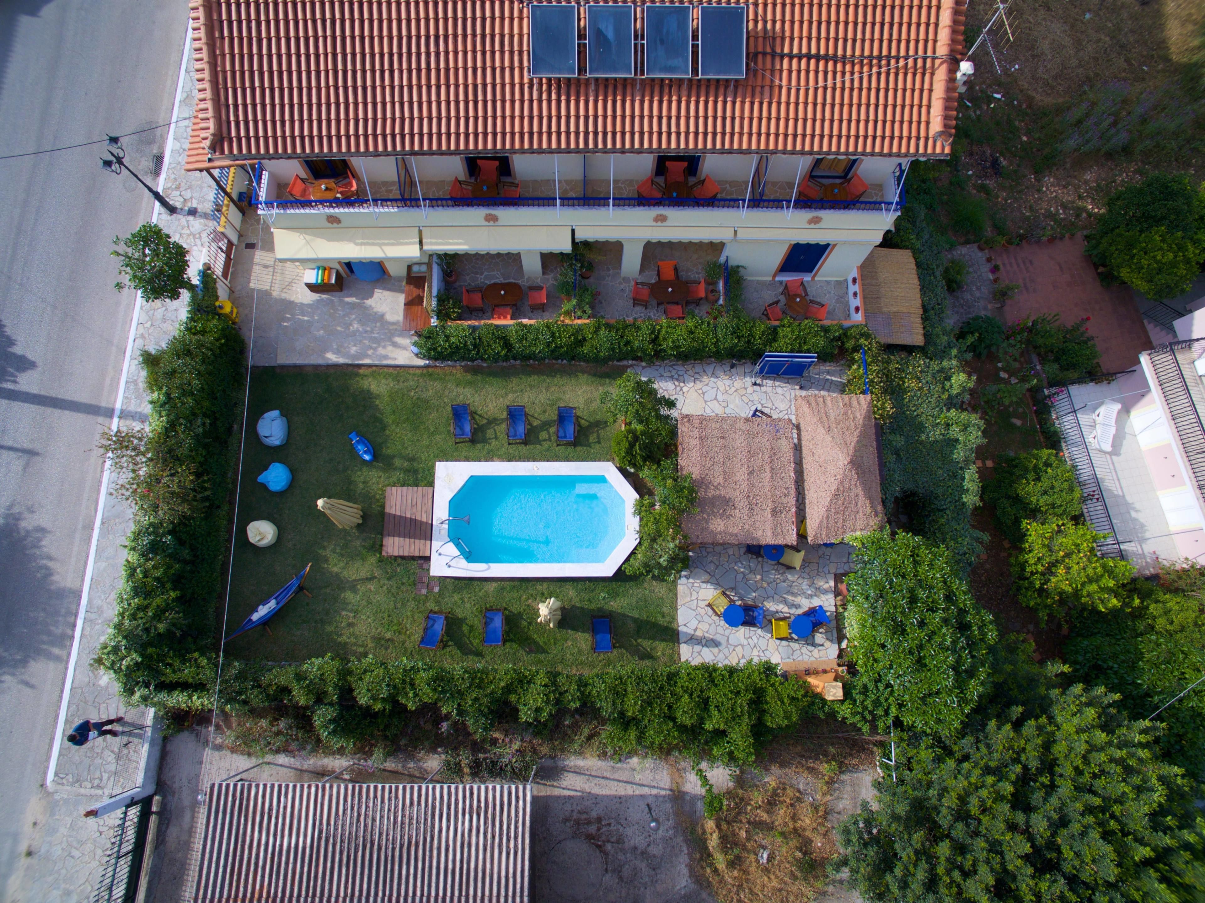 Eine Vogelperspektive eines Wohnhauses mit Swimmingpool, Sitzgelegenheiten im Freien und einer überdachten Terrasse.