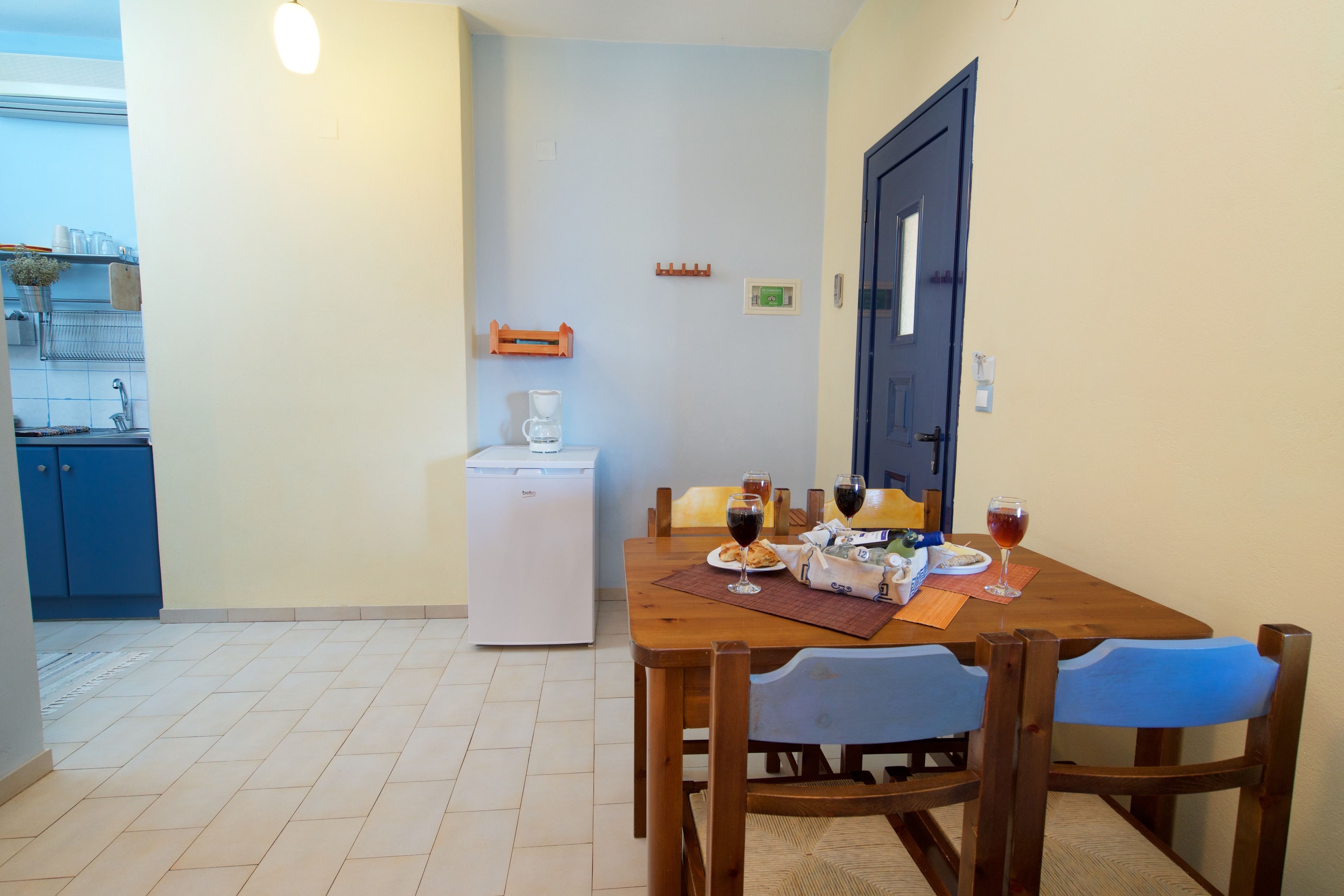 A dining area with a wooden table, chairs, and a refrigerator.