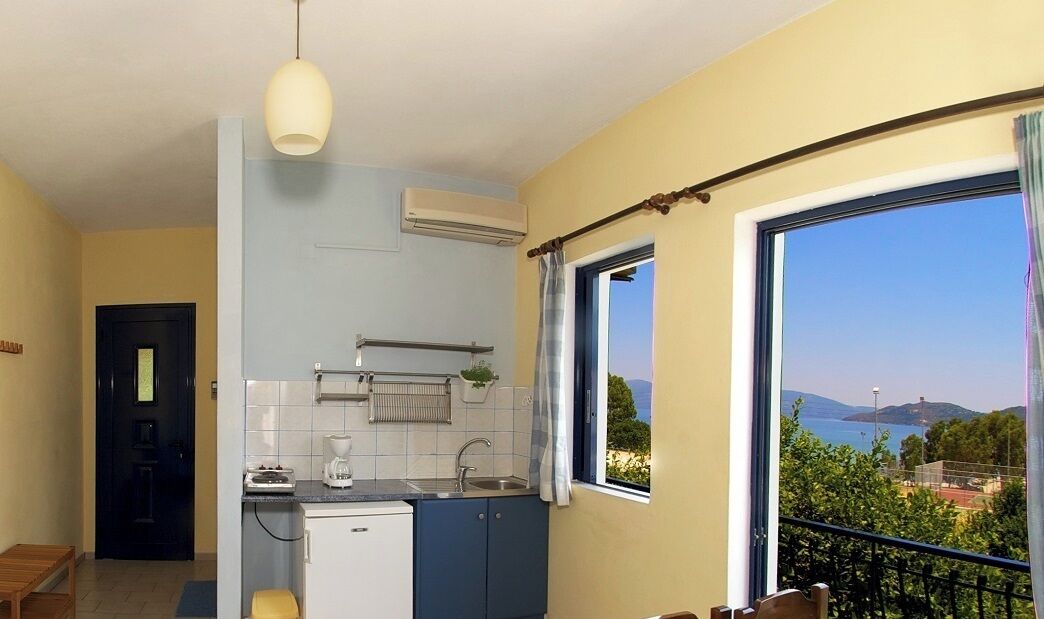 Una cocina compacta con ventana, un lavamanos pequeño y un horno empotrado.