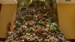 A rock garden with potted plants and figurines, a fire extinguisher, and a tiled floor. - Las Torres de Ugarte (Arequipa)