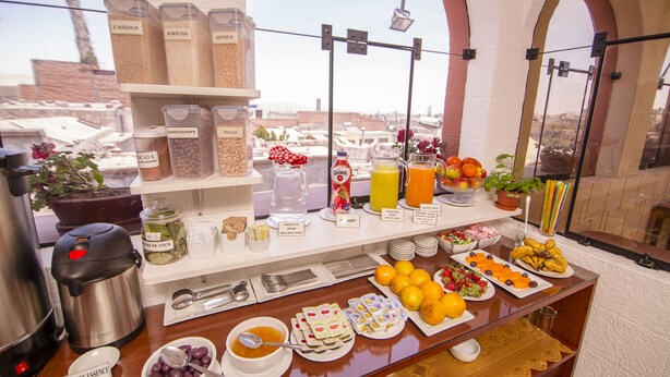 A buffet with various food items and beverages, including fruits, cereals, and a coffee station. - Las Torres de Ugarte (Arequipa)