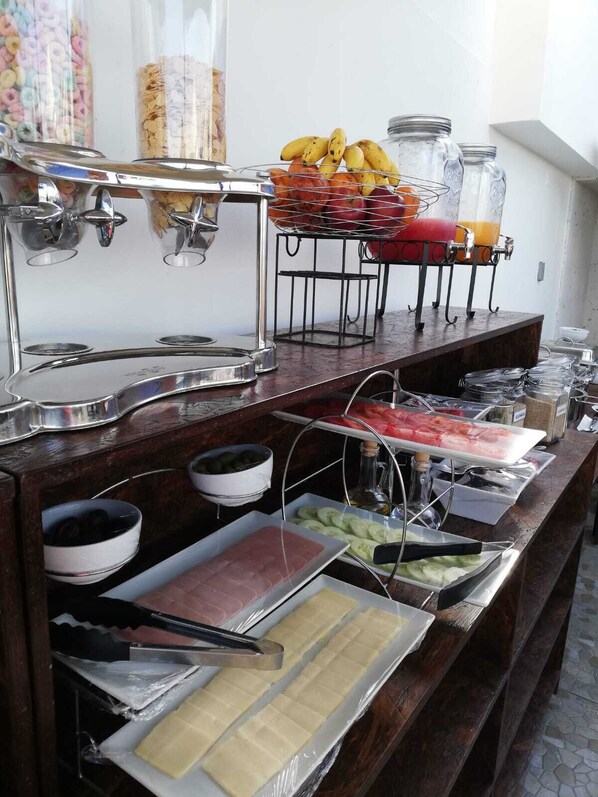 A buffet setup with various food items and a beverage station.