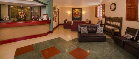 A lobby with a reception desk, seating area, and artwork.