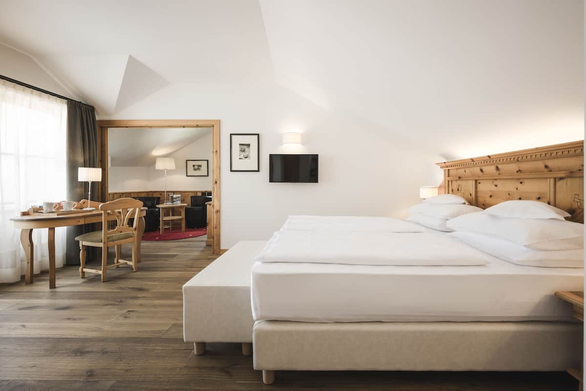 Una habitación de hotel con una cama, un escritorio y una silla.