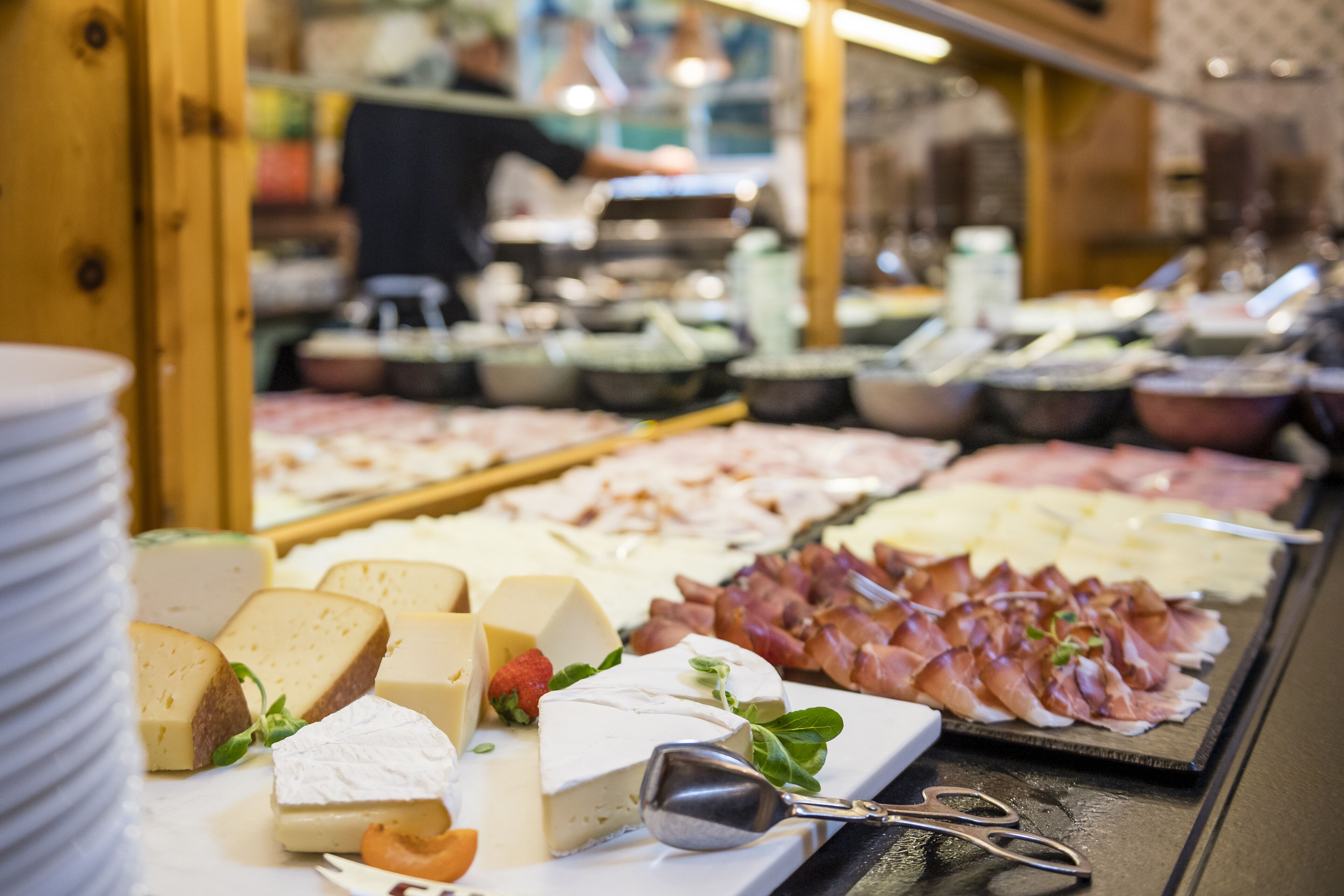 A cheese and meat display with various types of cheese and cured meats.