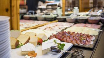 A cheese and meat display with various types of cheese and cured meats.