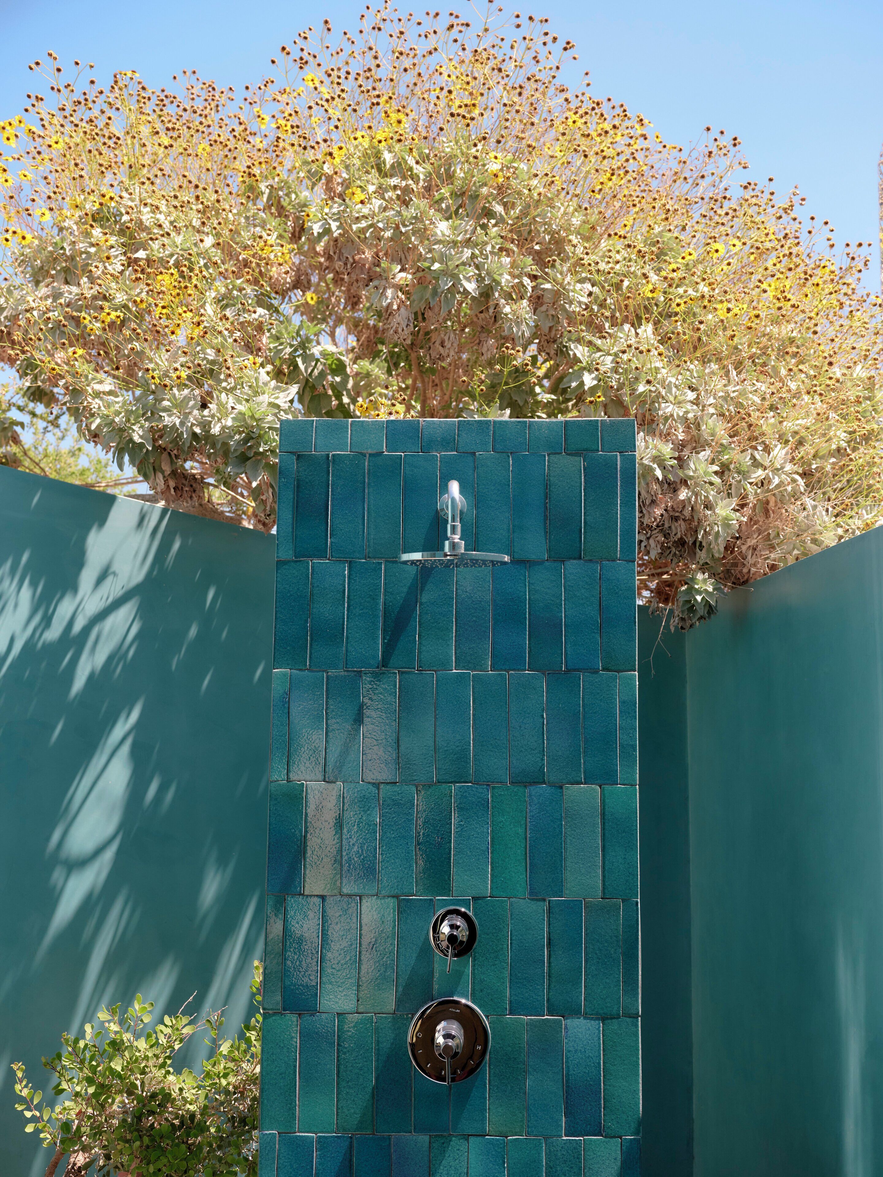 Eine vertikale Wand mit einem Wasserspiel und zwei Bedienknöpfen.