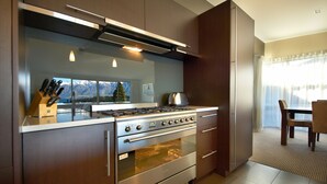 A modern kitchen with a built-in oven, stainless steel appliances, and a knife block.