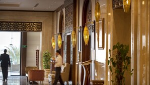 A lobby with a marble floor, a reception desk, and a large plant. - SUNRISE Arabian Beach Resort (Sharm El Sheikh)