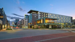 A modern hotel with a prominent entrance, multiple floors, and a well-lit facade.