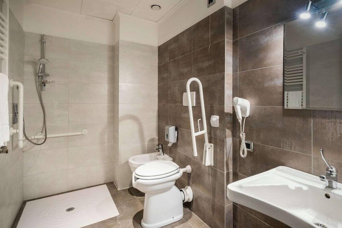 A modern bathroom with a shower, toilet, and sink.