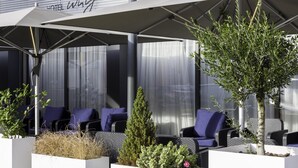 An outdoor seating area with white planters, blue cushioned chairs, and a canopy. - Best Western Premier Why Hotel (Lille)