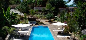 Una piscina al aire libre, tumbonas