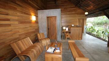 Relax in a cozy reception area with a wooden desk, comfortable seating, and a scenic view.