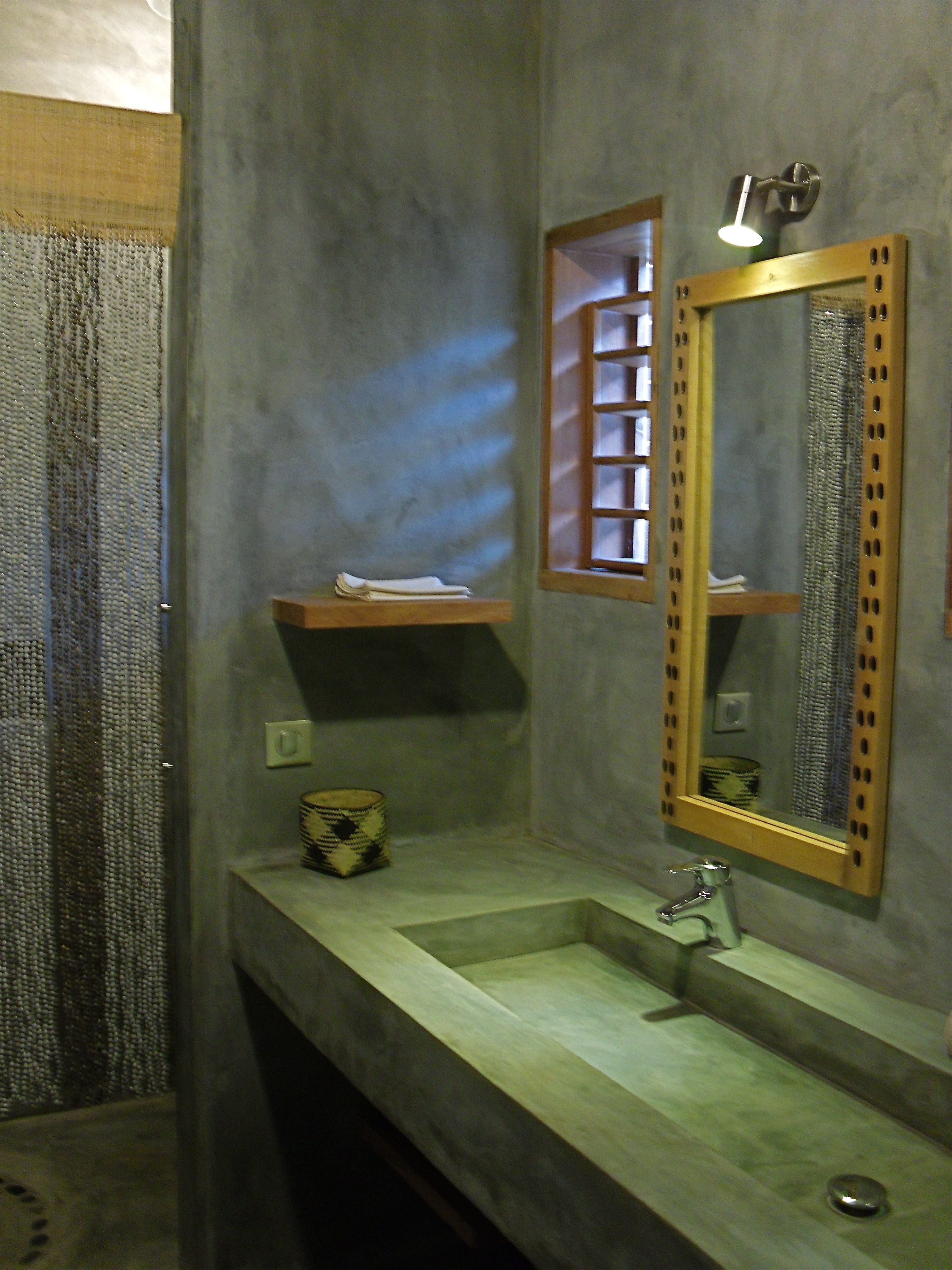 A bathroom with a marble sink, a mirror with a wooden frame, and a towel rack.